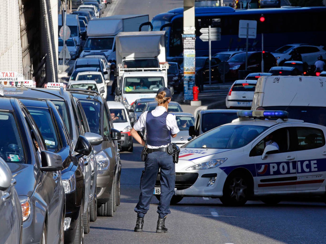 Policemen stand on a road as taxi drivers on strike block the traffic during a national protest against car-sharing service Uber in Marseille 