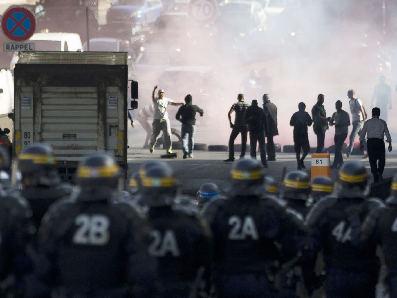French CRS riot police face demonstrators as striking taxi drivers block the Boulevard Peripherique near Porte Maillot in Paris 