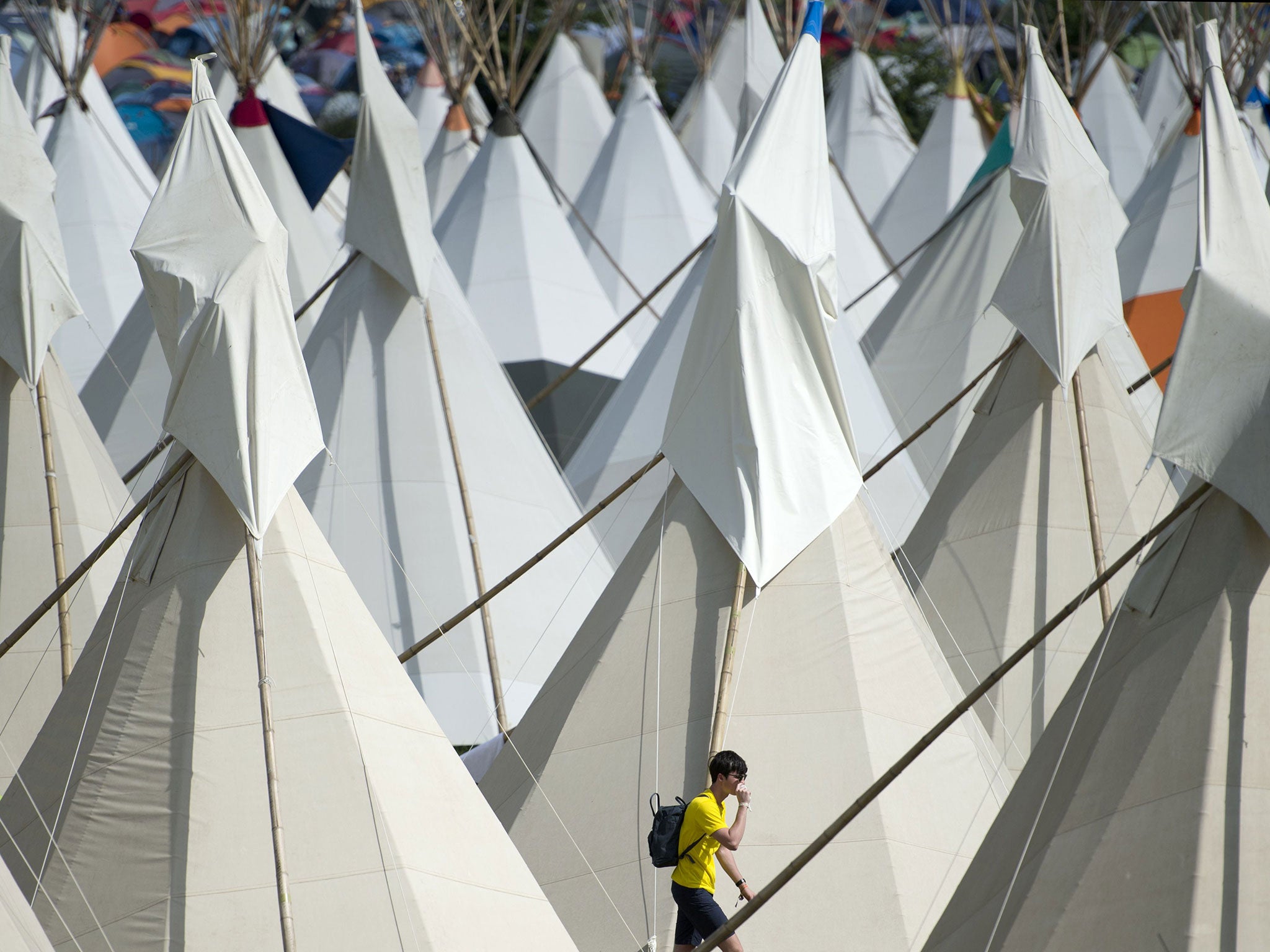 A reveller walks through the Tipi Field area of the Glastonbury Festival of Music and Performing Arts on Worthy Farm near the village of Pilton in Somerset