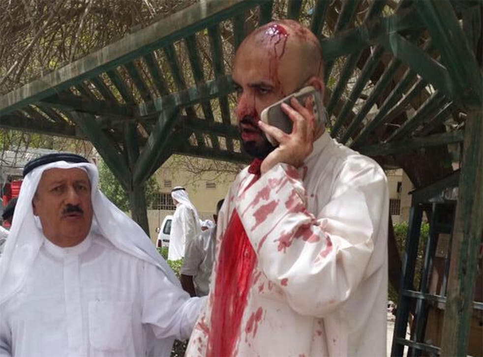 A man speaks on the phone in the wake of the Kuwait mosque bombing
