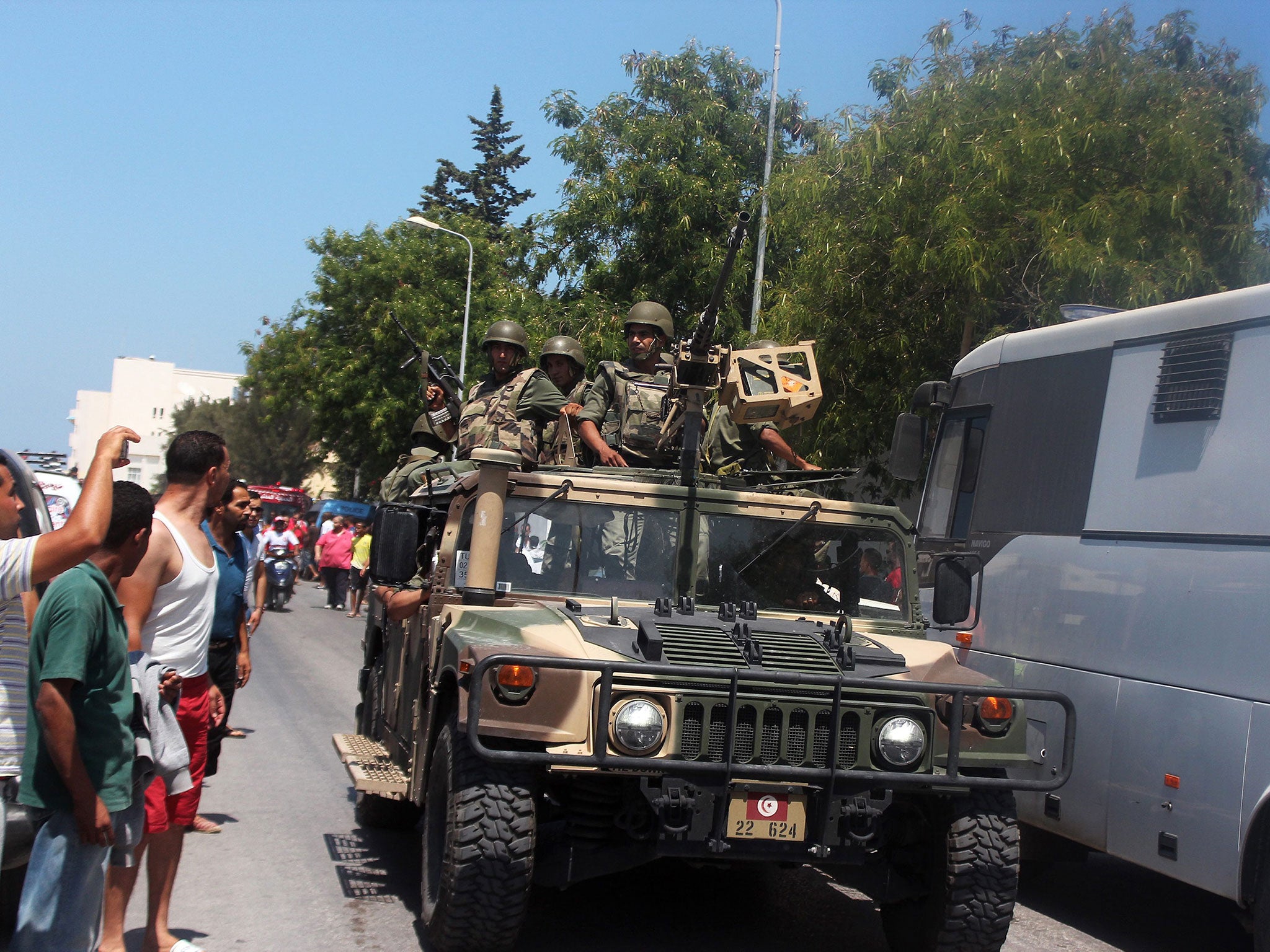 Members of the Tunisian security forces in an amroured vehicle patrol a street in al-Sousse