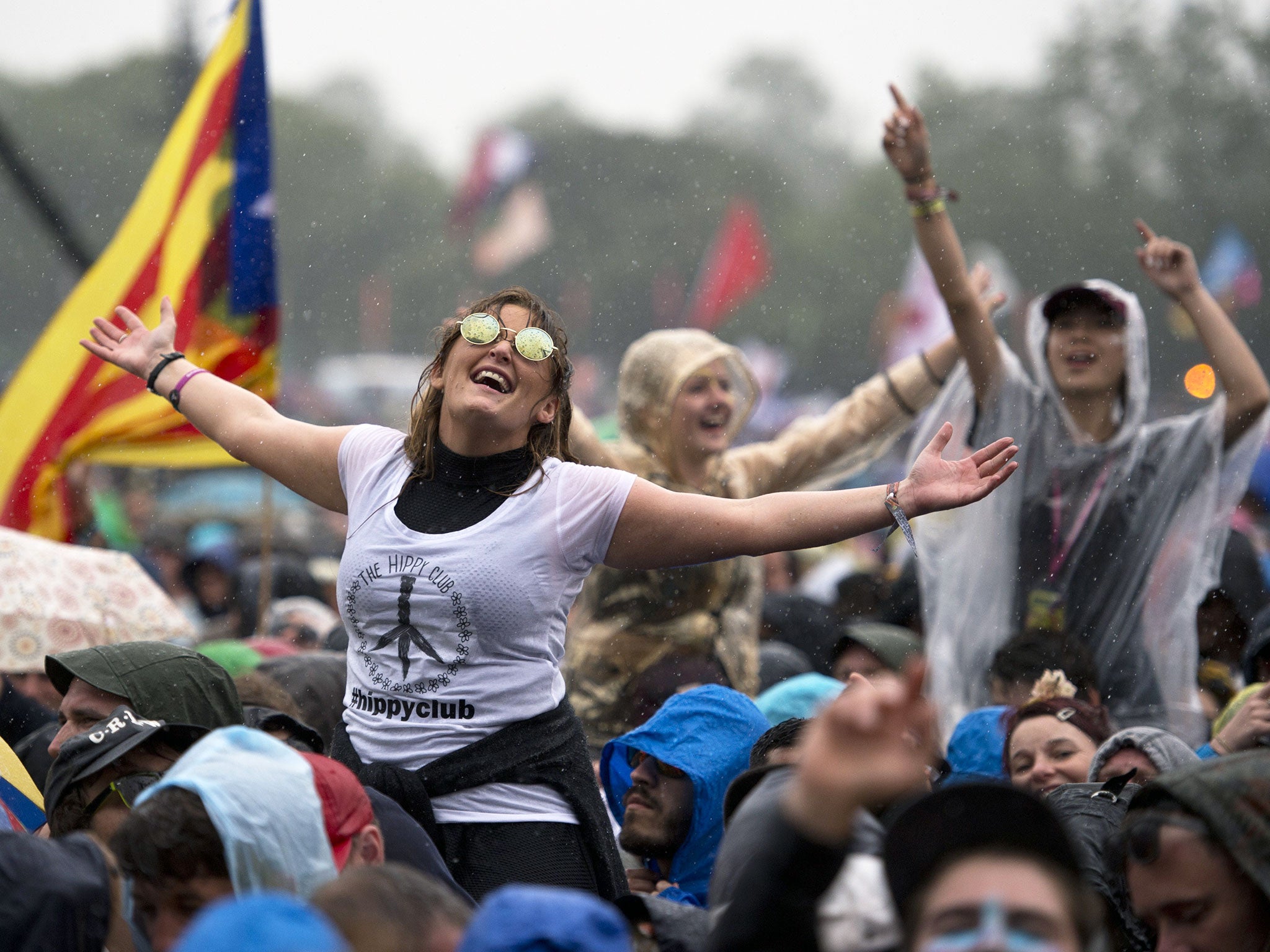 Festival goers wear raincoats as they watch Alabama Shakes perform on the Pyramid Stage on the first official date of the Glastonbury Festival of Music and Performing Arts on Worthy Farm near the village of Pilton in Somerset