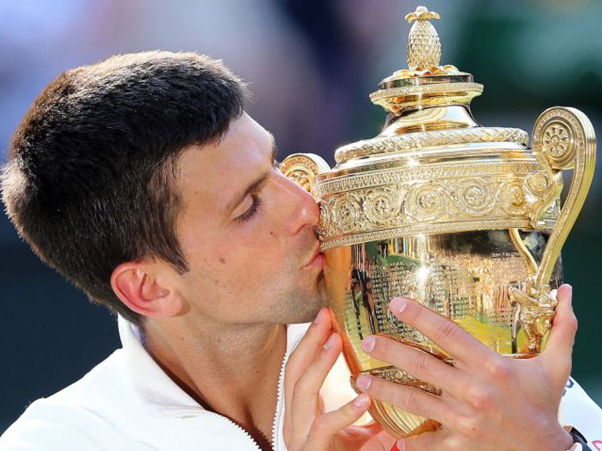 Djokovic kisses the Wimbledon trophy after defeating Roger Federer