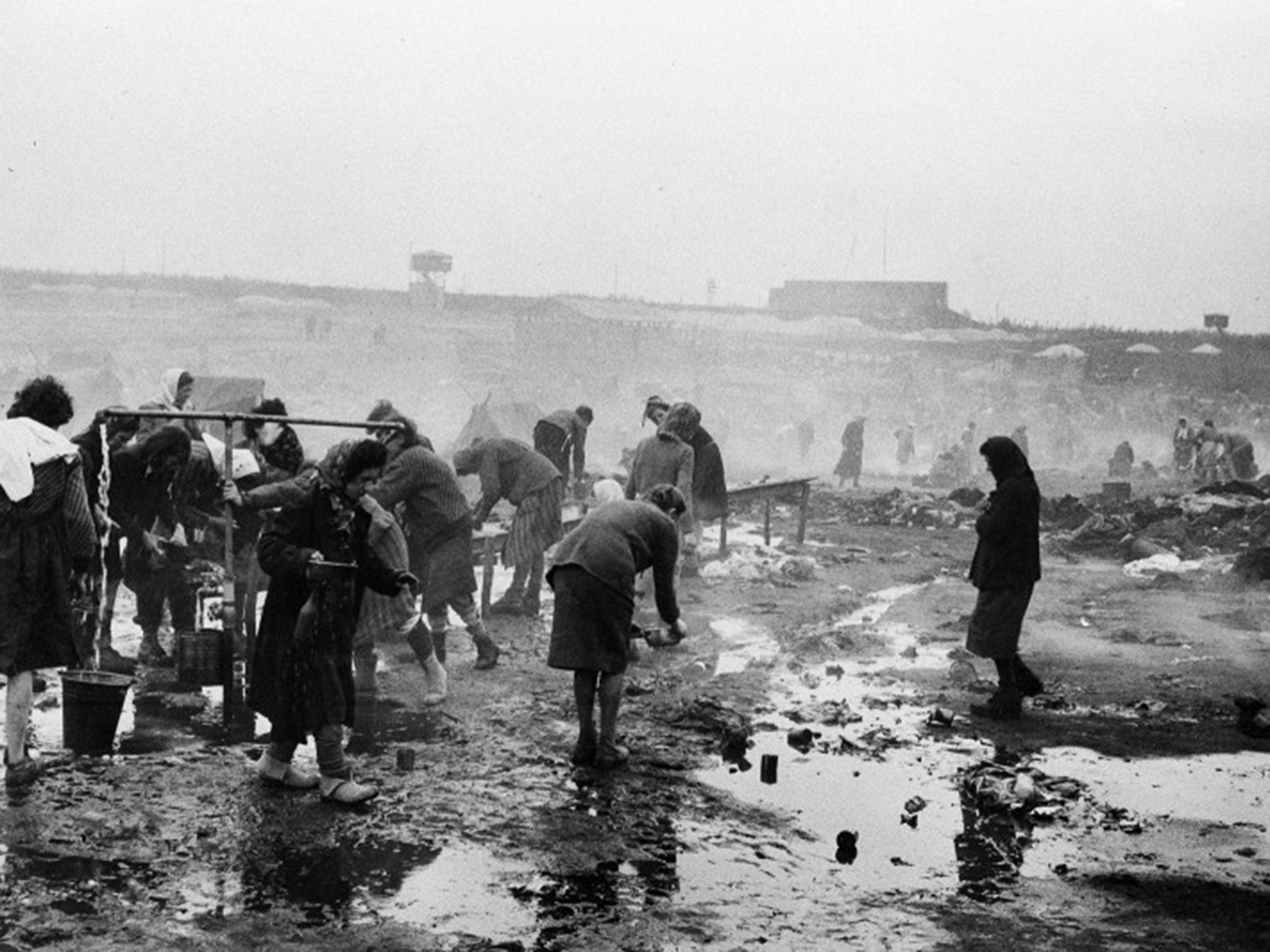 Inmates at Bergen-Belsen concentration camp use water from a pond to wash for the first time following their liberation by British troops