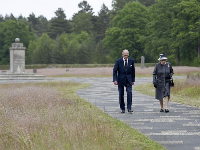 Britain's Queen Elizabeth and Prince Philip walk past mass graves in front of the Jewish monument in the grounds of the site of the former Nazi German concentration camp Bergen-Belsen
