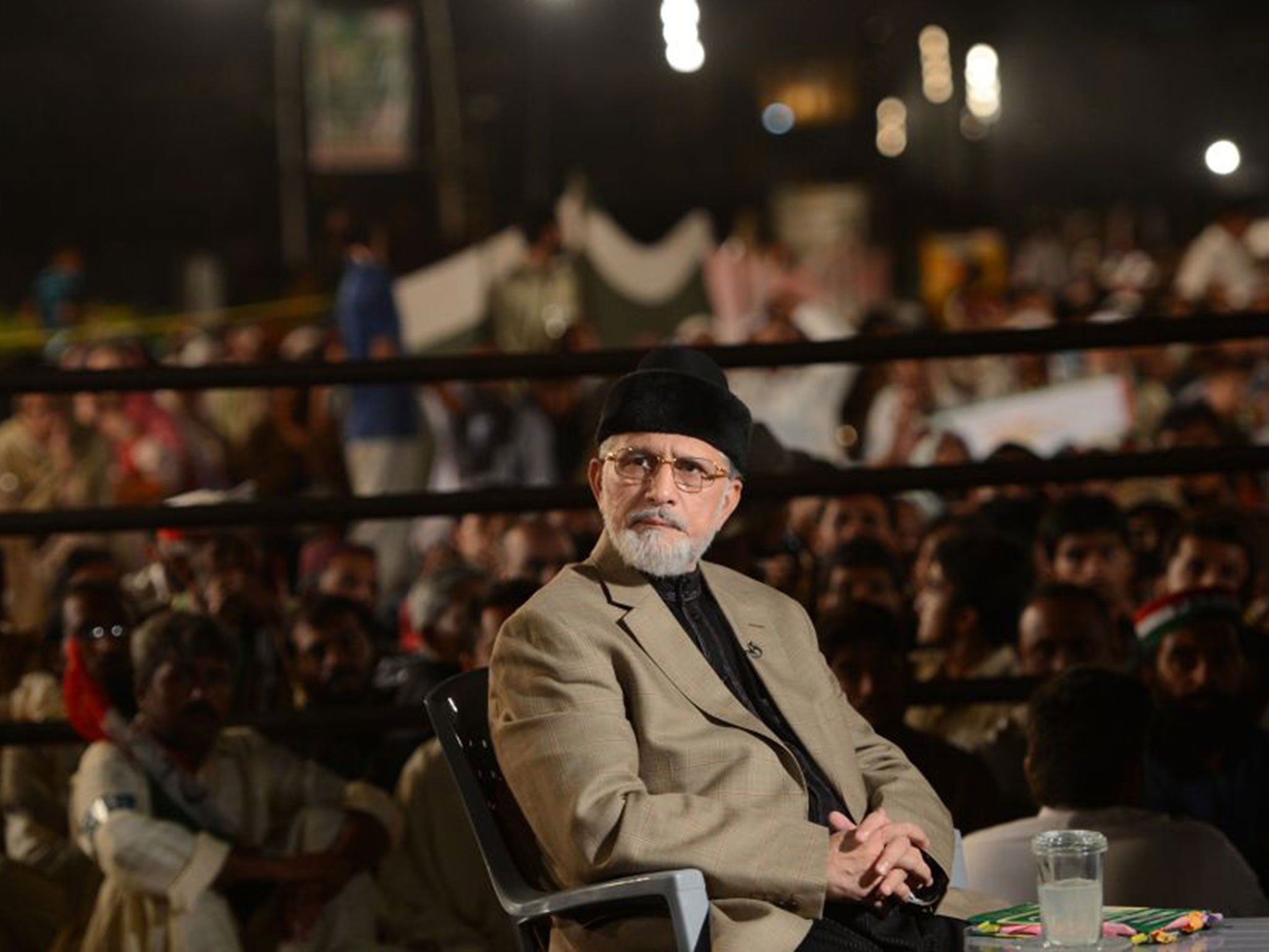 Pakistani populist cleric Tahir-ul-Qadri looks on as he speaks with media representatives during an anti-government protest outside the parliament in Islamabad