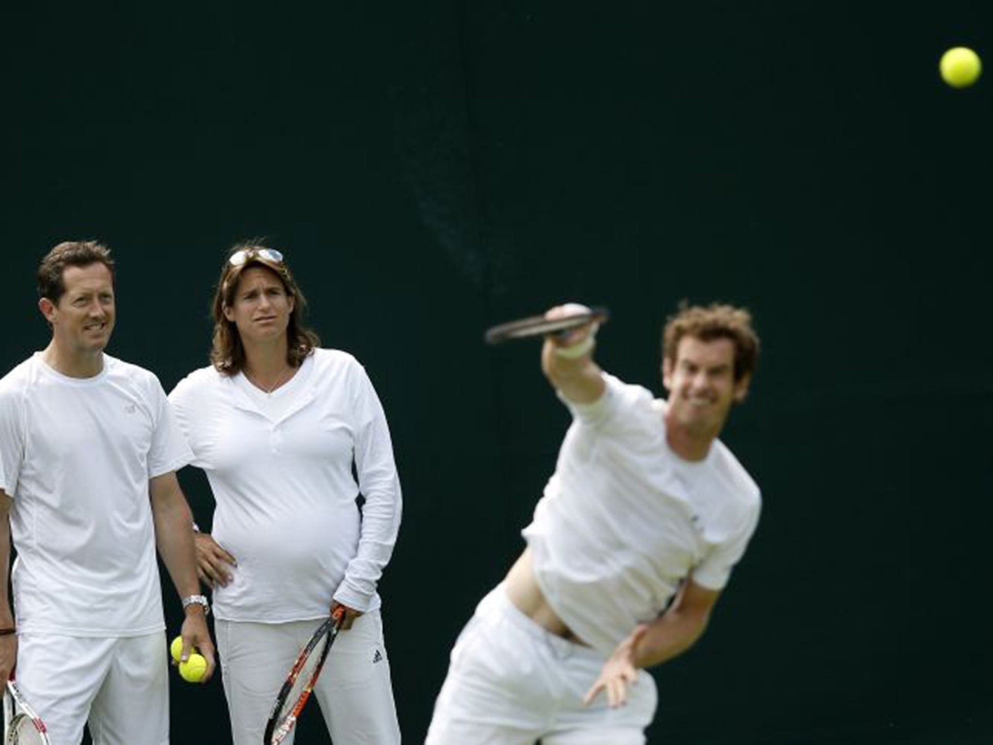 Jonas Bjorkman and Amélie Mauresmo look on as Andy Murray practises serving at Wimbledon yesterday