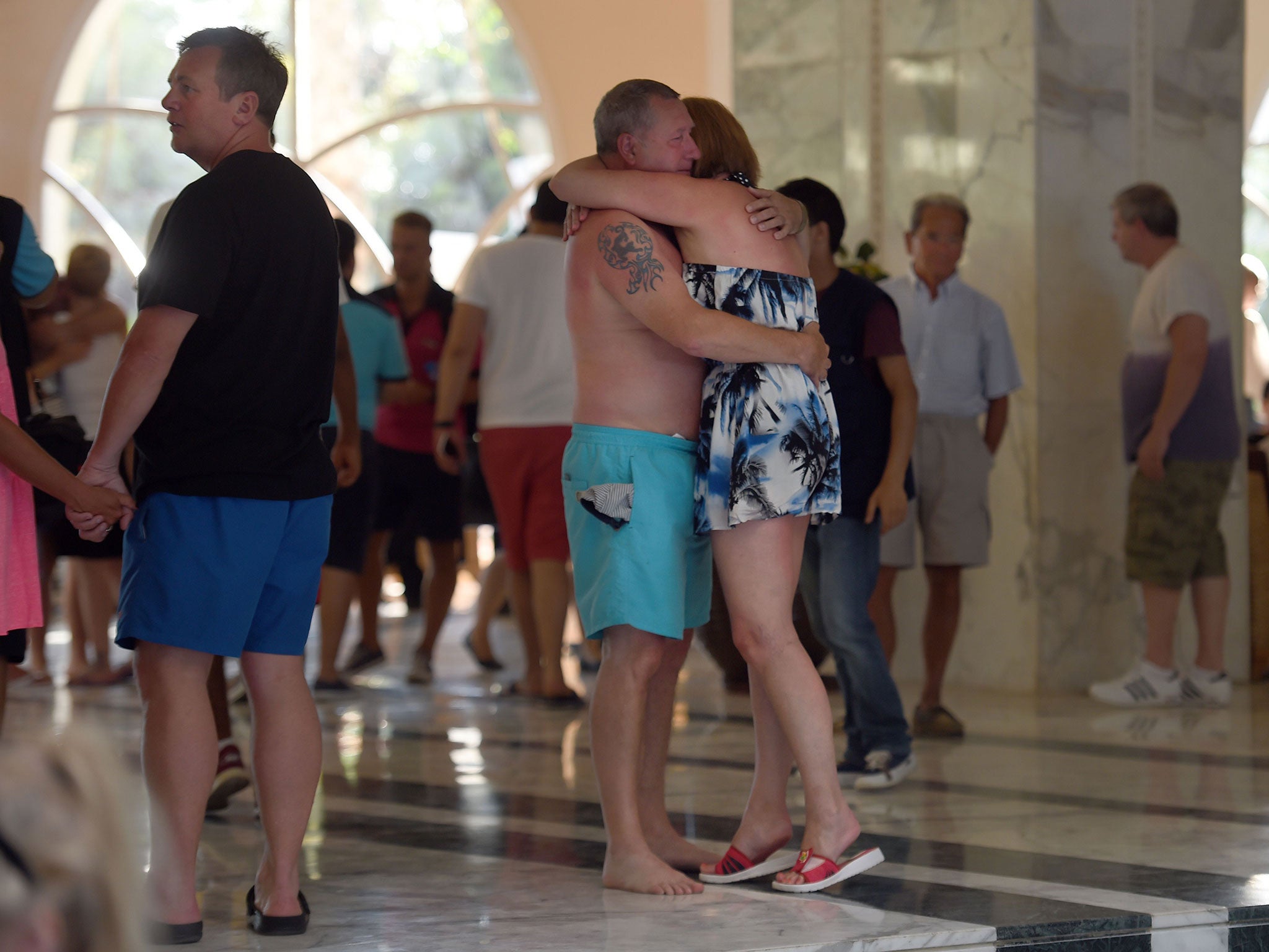 Tourists comfort each other after the mass shooting in the resort town of Sousse