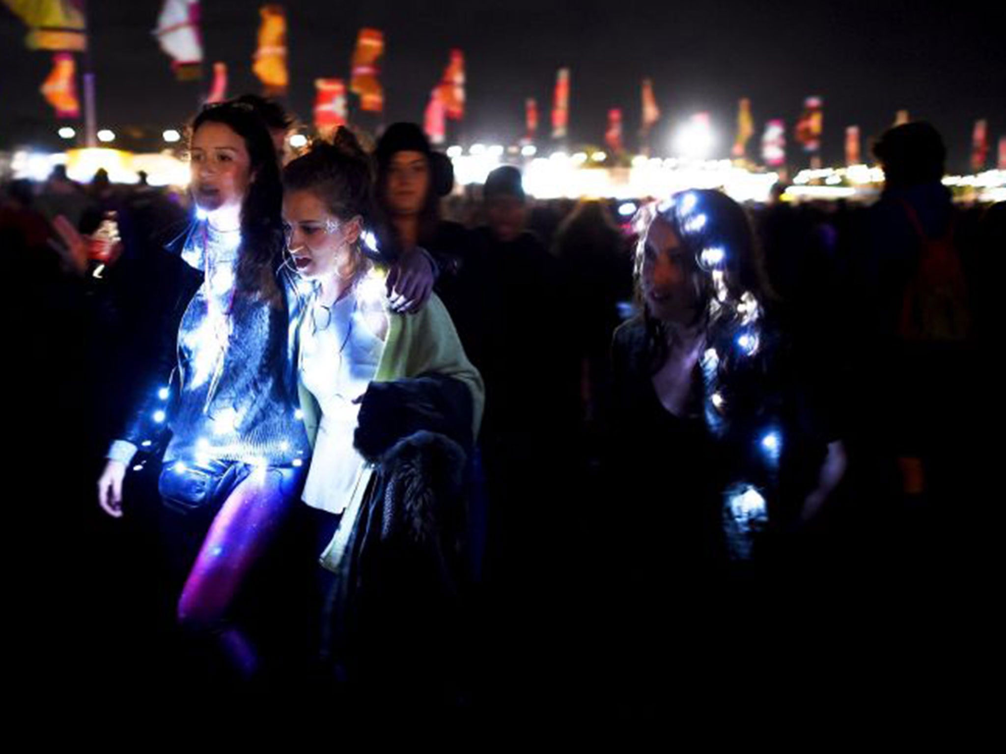 Revellers are lit up as they walk through Worthy Farm