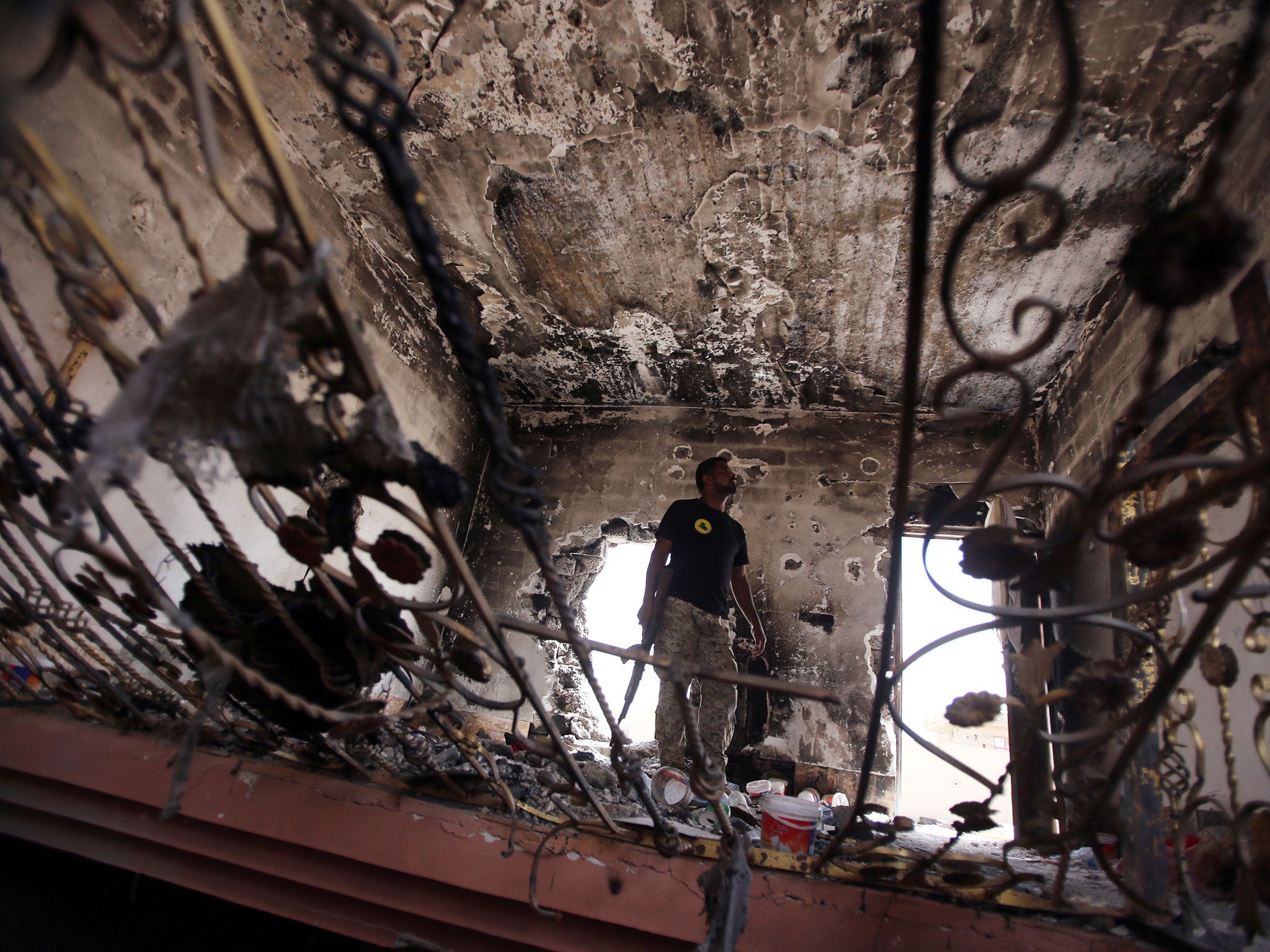 An Iraqi soldier inspects a burnt out building in Tikrit