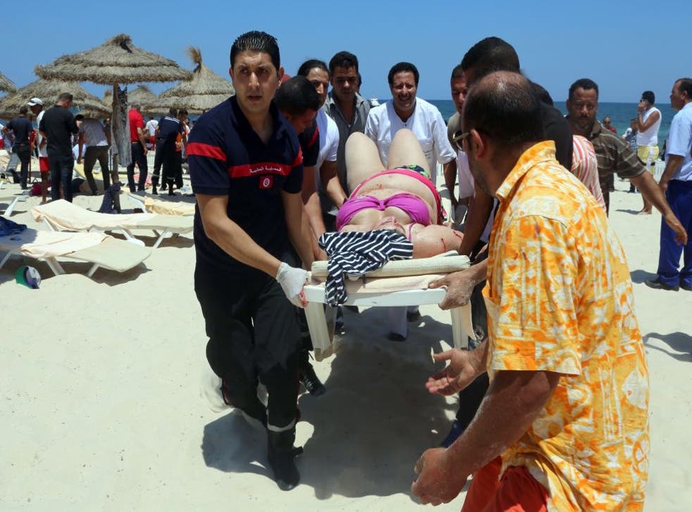 A woman injured in the attack at Sousse is carried from the beach 