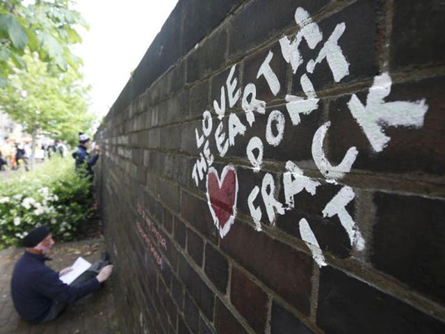 Anti-fracking protesters write messages on a wall during a demonstration outside County Hall in Preston last year