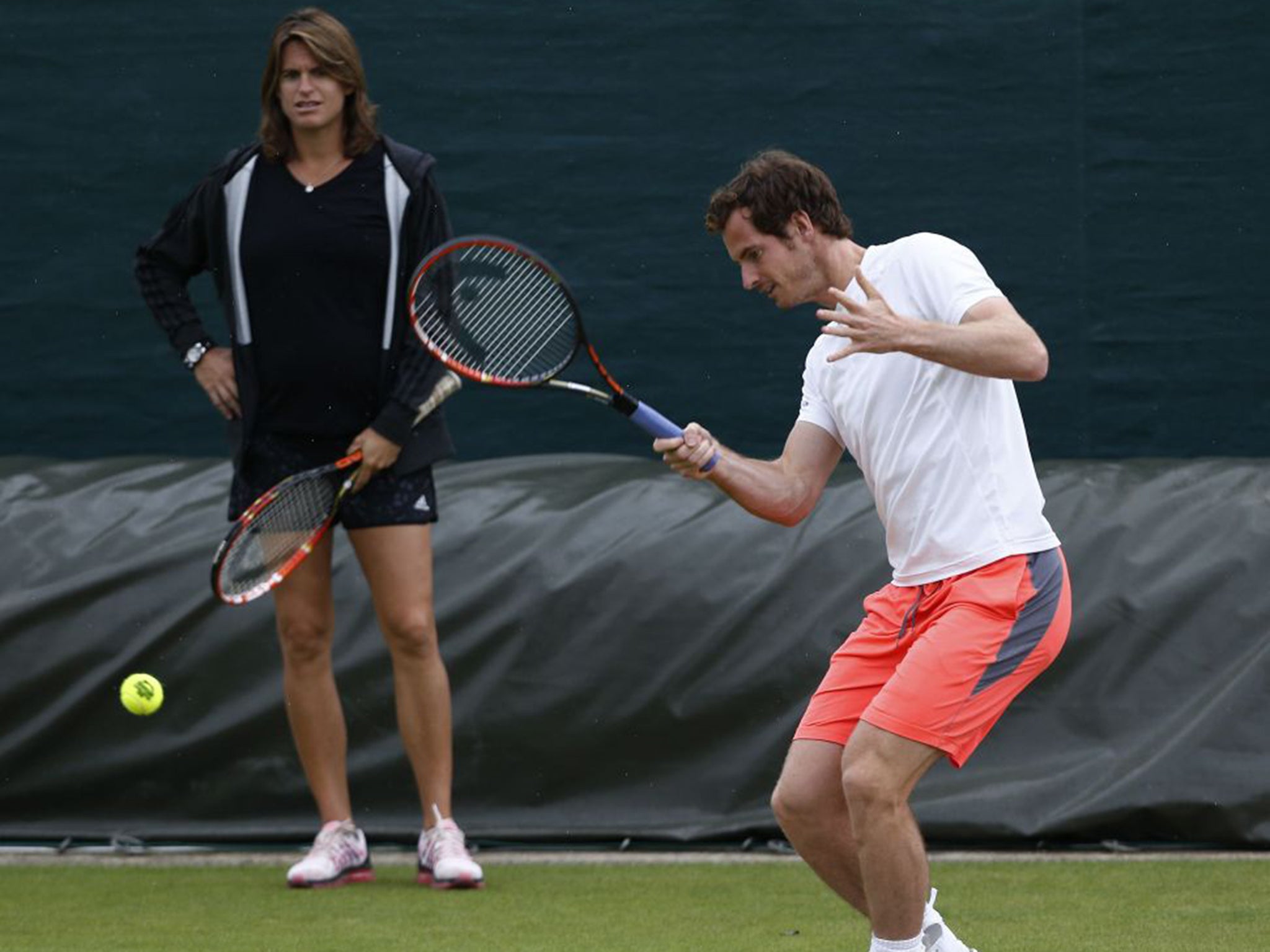 Andy Murray trains at Wimbledon yesterday under the watchful eye of coach Amélie Mauresmo