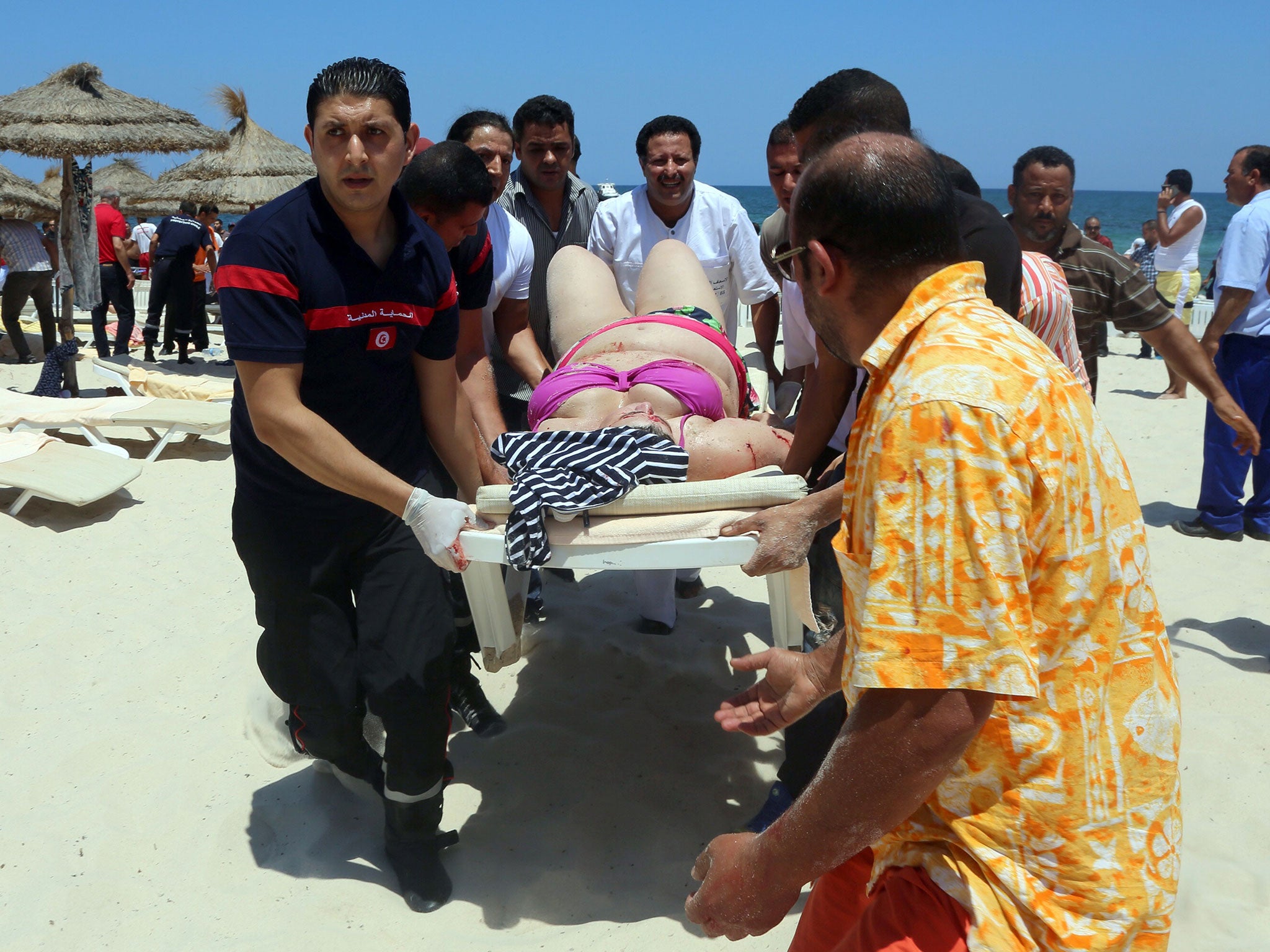 Tunisian medics carry a woman on a stretcher in the resort town of Sousse