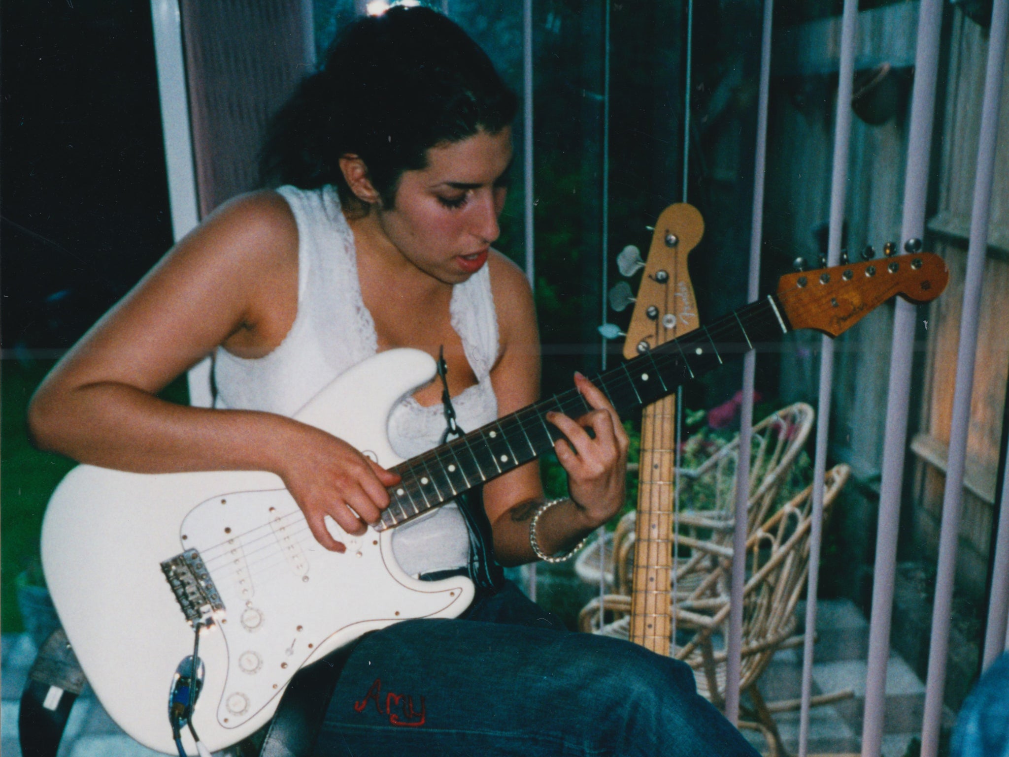 Amy Winehouse as a young girl, playing the guitar at her North London home