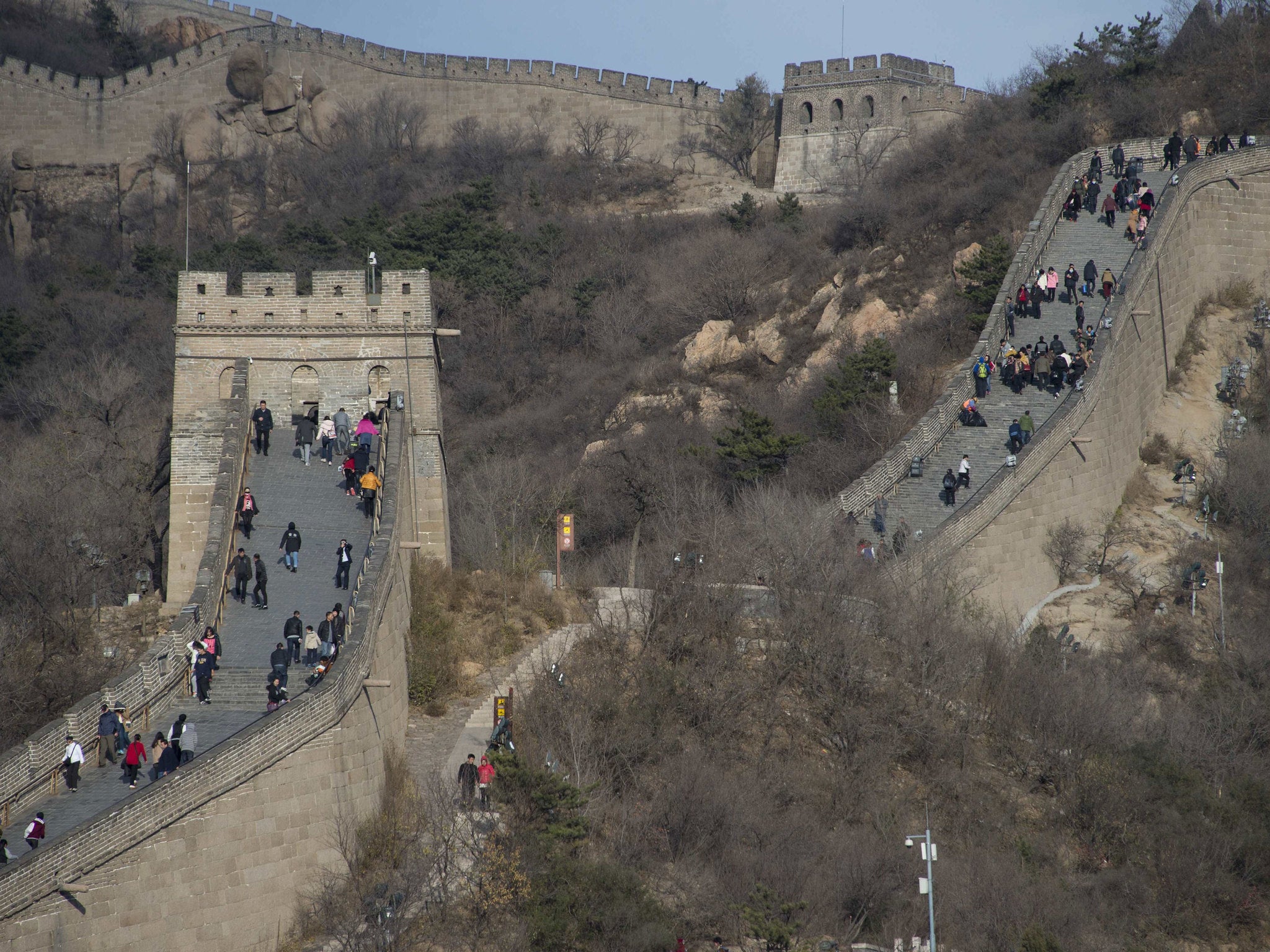 People walk along a section of the Great Wall of China at Badaling, north of Beijing, on November 11, 2014. AFP PHOTO/Nicholas KAMM