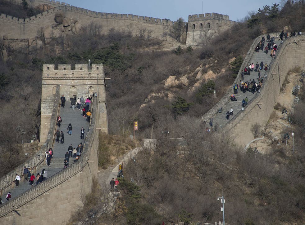 File:  People walk along a section of the Great Wall of China at Badaling, north of Beijing, on November 11, 2014