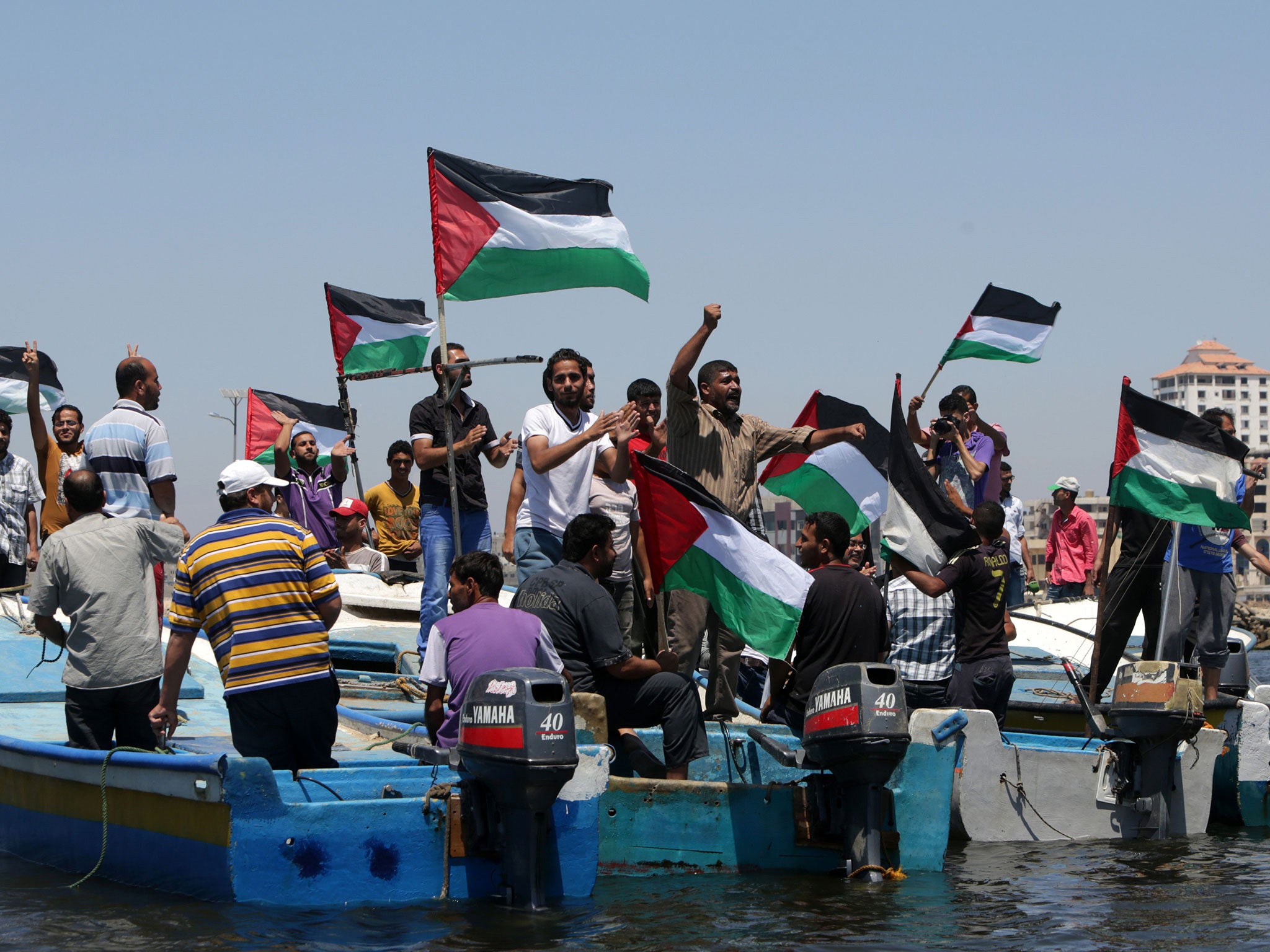 Palestinians rally yesterday in the port of Gaza in support of a flotilla that aims to break the blockade