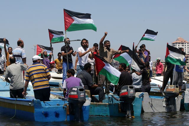 Palestinians rally yesterday in the port of Gaza in support of a flotilla that aims to break the blockade