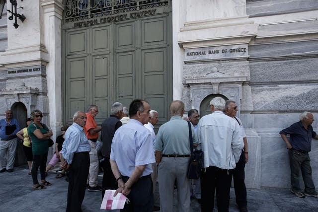 Customers wait outside a closed branch of the National Bank of Greece in Athens