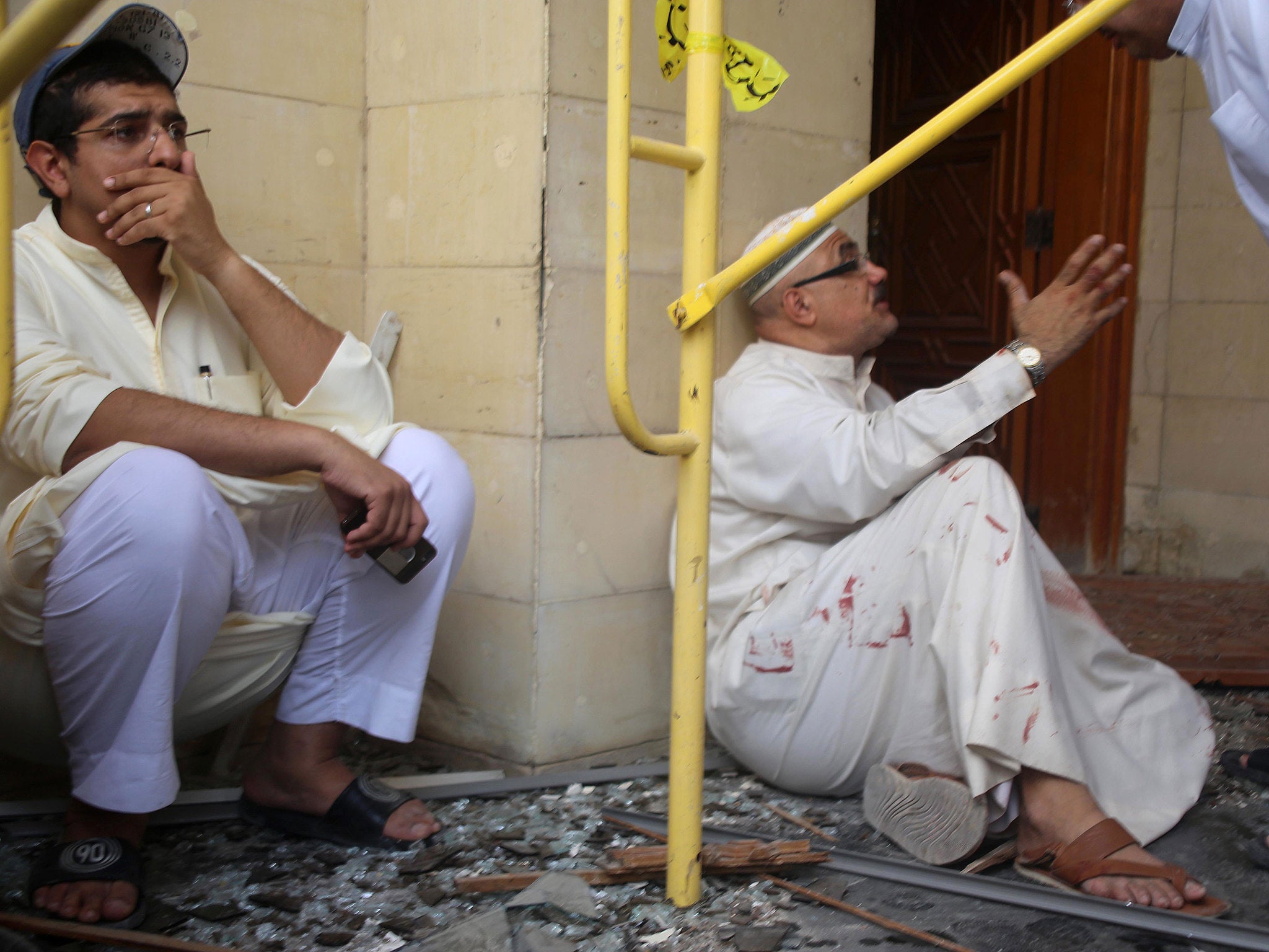 Two men react to the chaos caused by Friday's suicide bombing