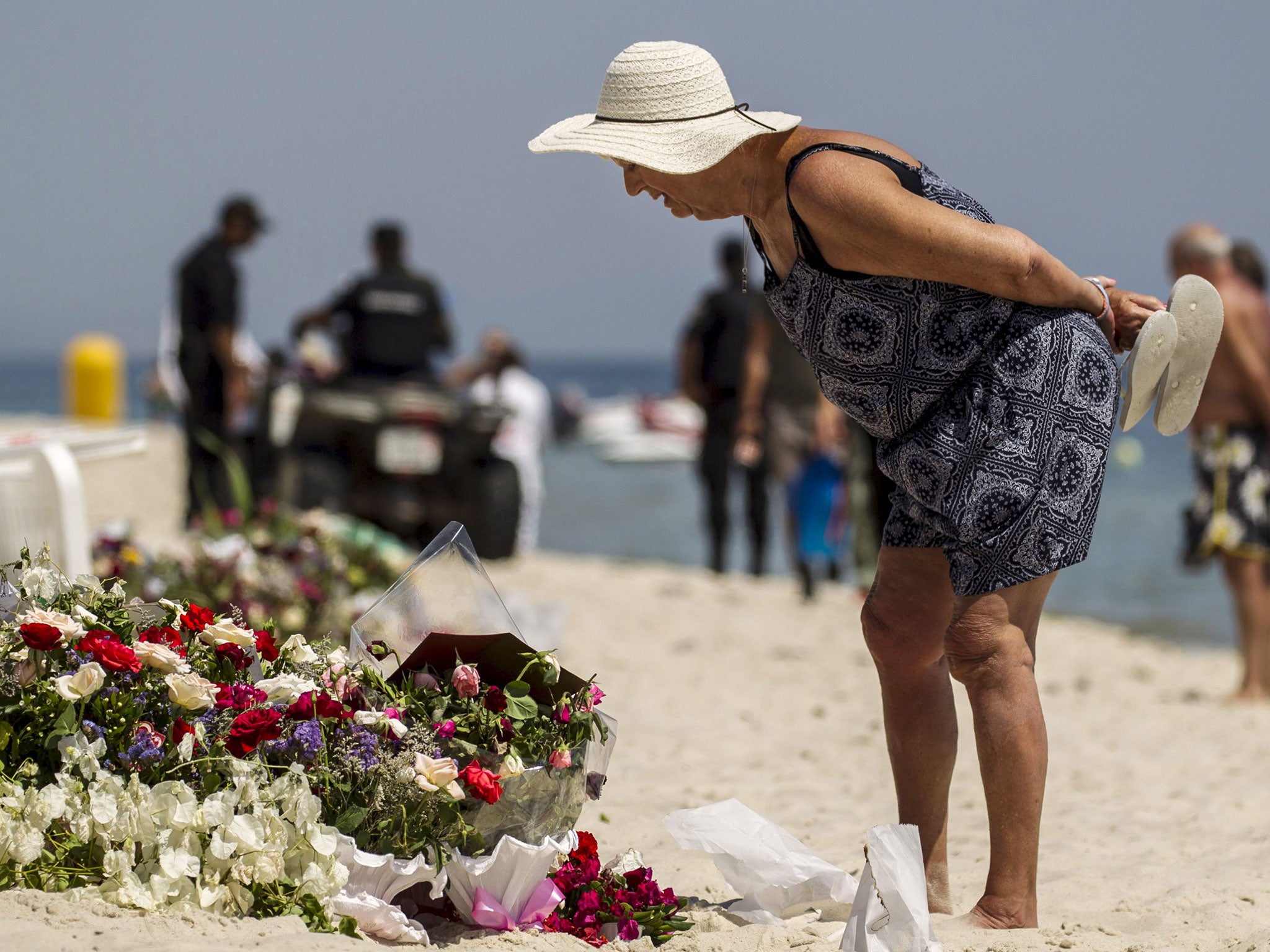 A tourist reads messages left at a makeshift memorial at the beach near the Imperial Marhaba resort, which was attacked by a gunman in Sousse, Tunisia