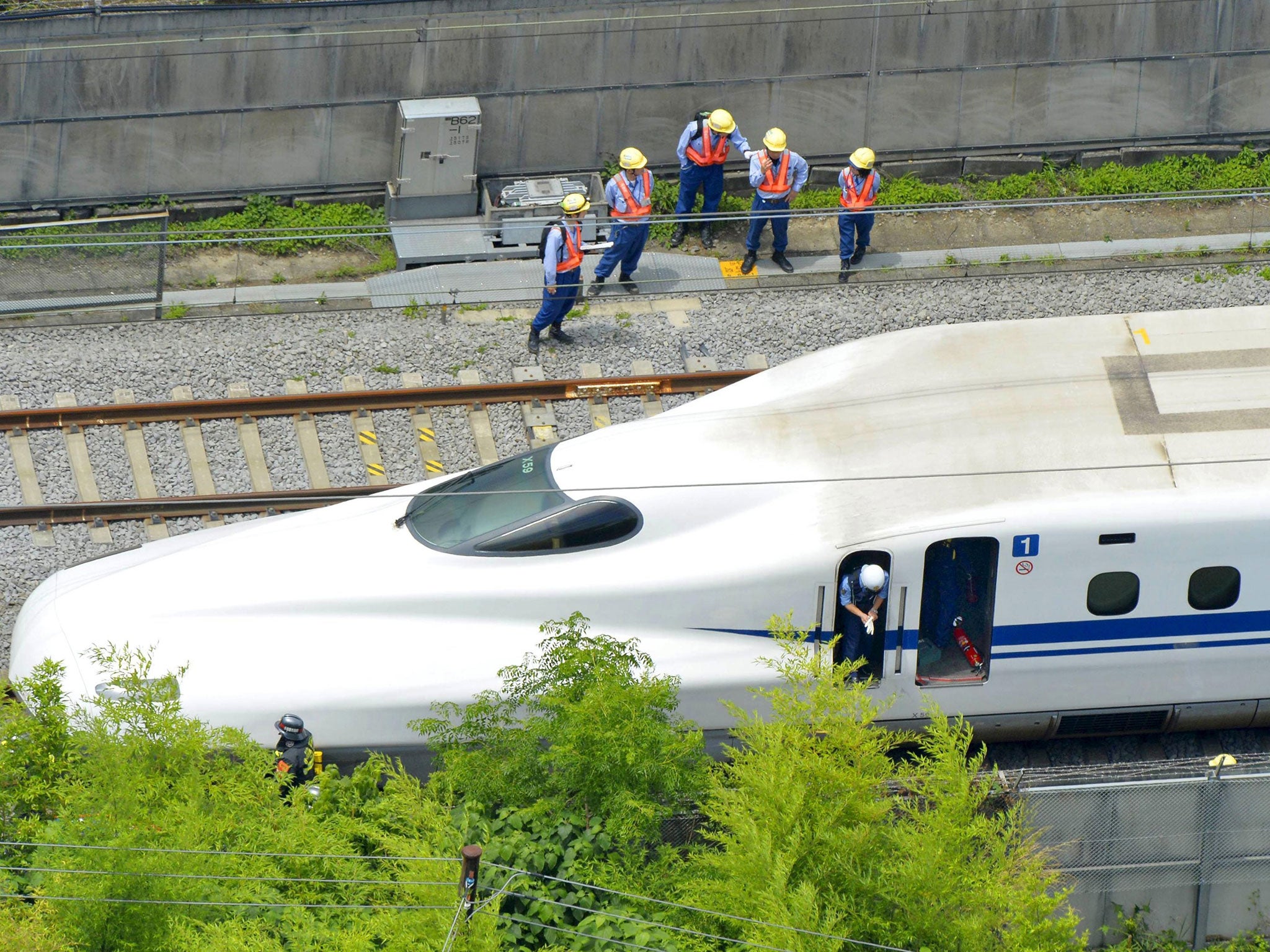 Police officers investigate a Shinkansen bullet train after it made an emergency stop in Odawara, south of Tokyo