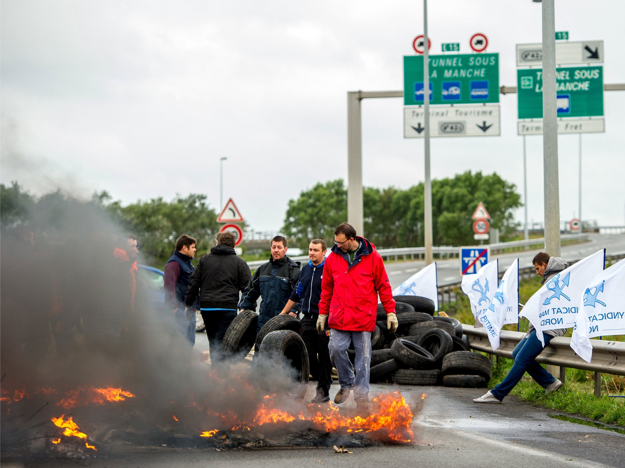 Striking workers from My Ferry Link light a tyre fire to block access to the Channel Tunnel entrance during the first strike in France on 23 June