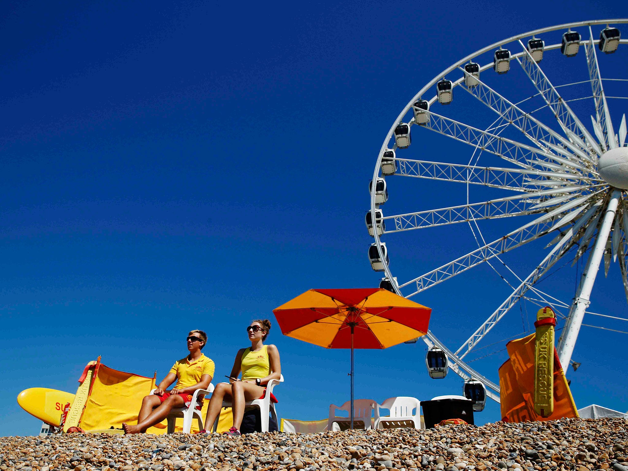 Lifeguards Chris Payne (L) and Nina Bassam keep watch on a hot Summer day at Brighton beach