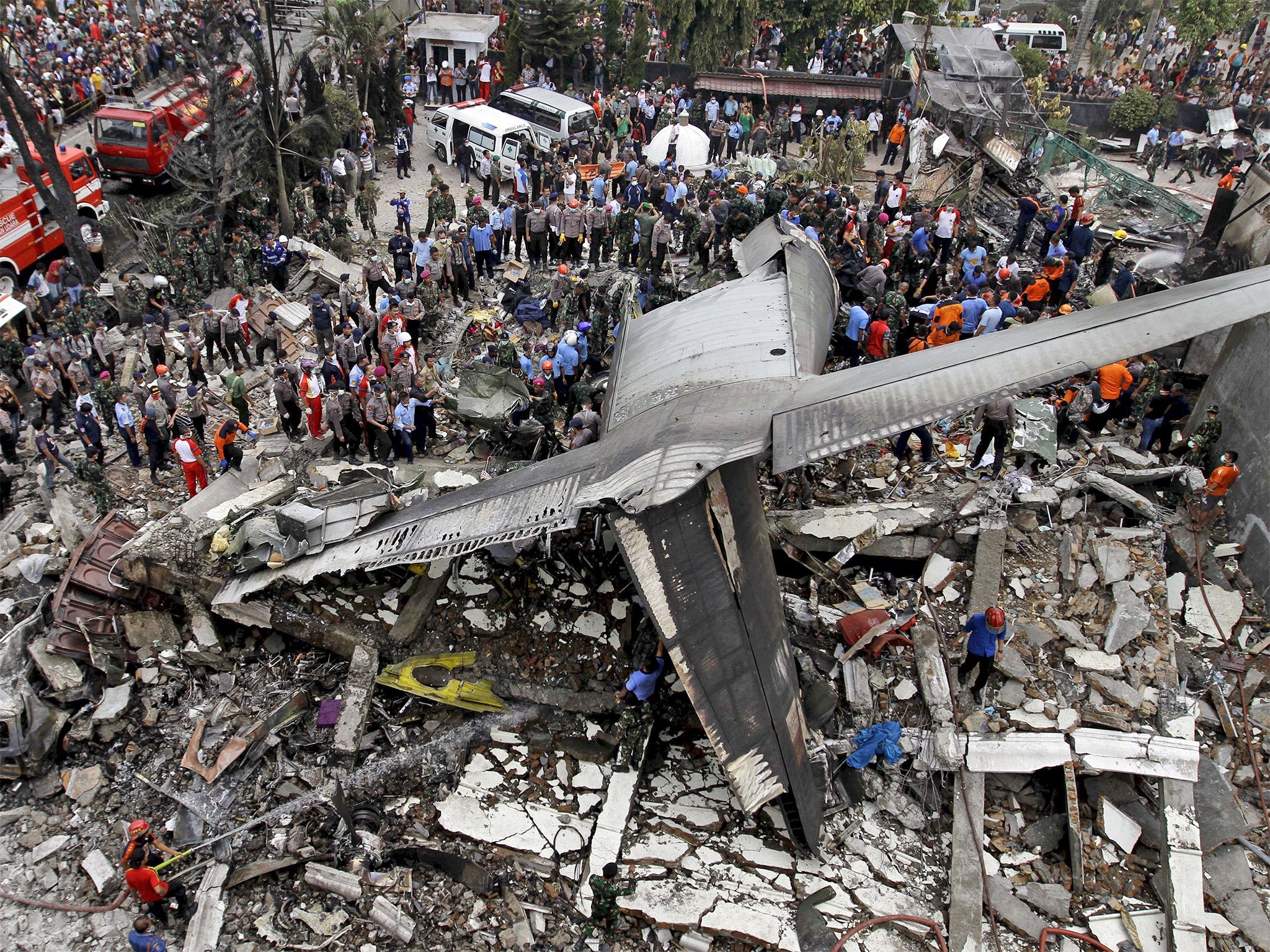 Security forces and rescue teams examine the wreckage of the military plane