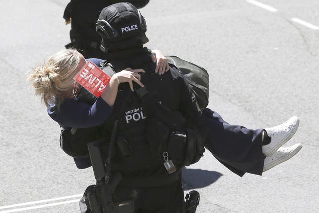 A police officer carries a casualty to safety