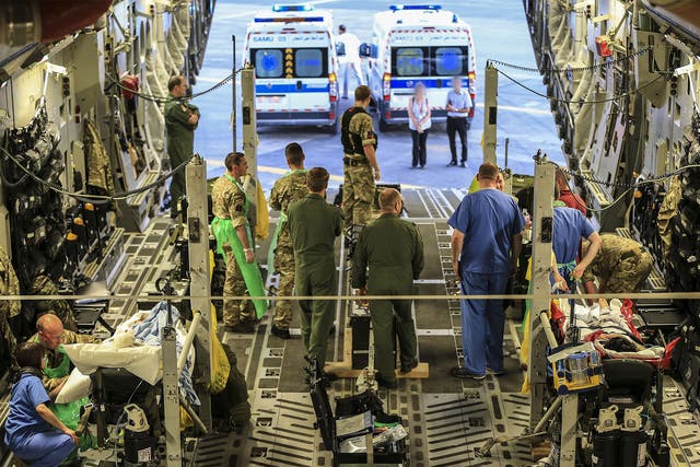 Military personnel attend to injured British tourists being flown back to the UK for treatment on Monday