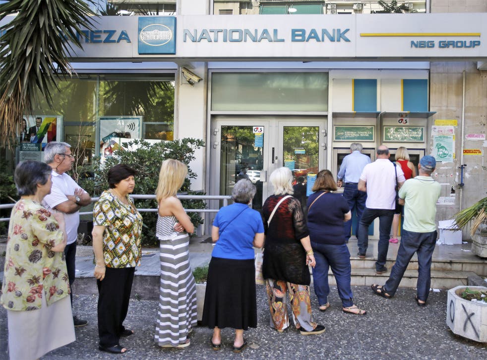People stand in a queue to use an ATM outside a closed bank in Athens