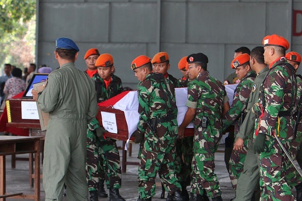 Soldiers carry a coffin bearing the body of military personnel at a send-off ceremony at the military airbase in Medan this morning