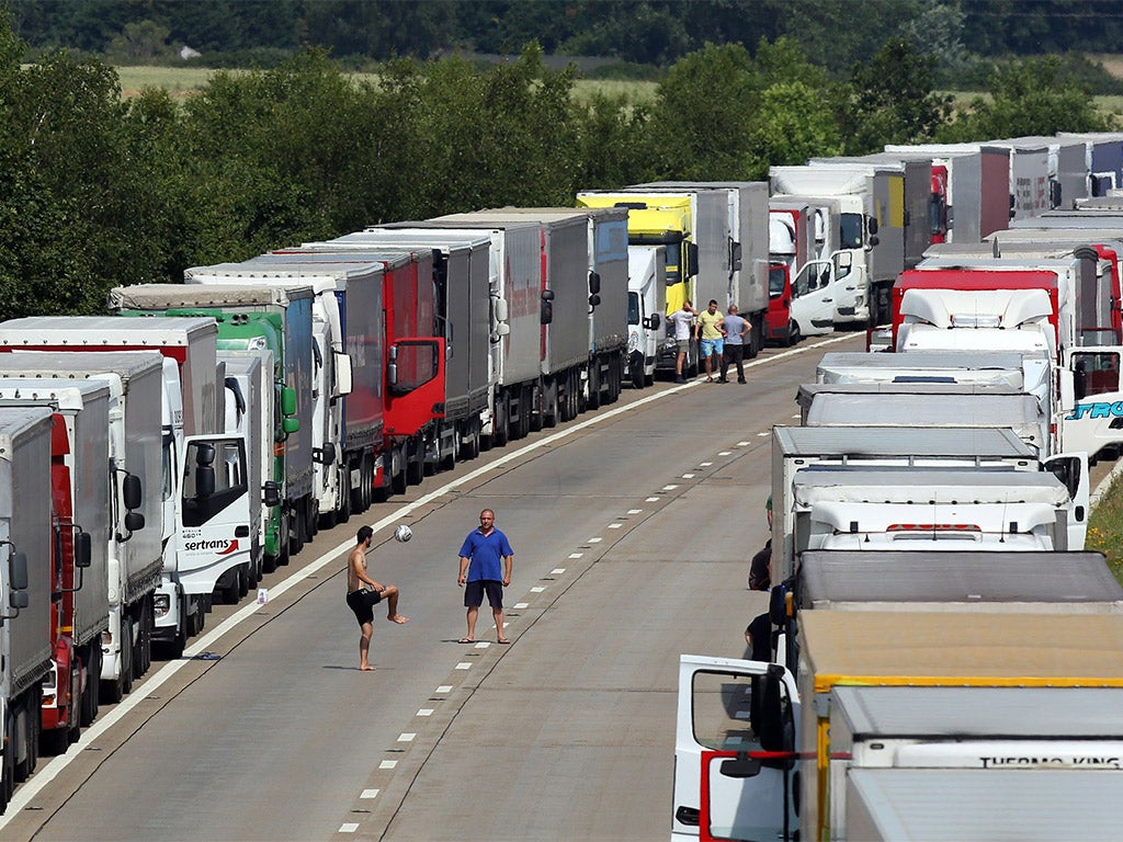 People play football amongst lorries parked on both carriageways of the M20 in Ashford, Kent