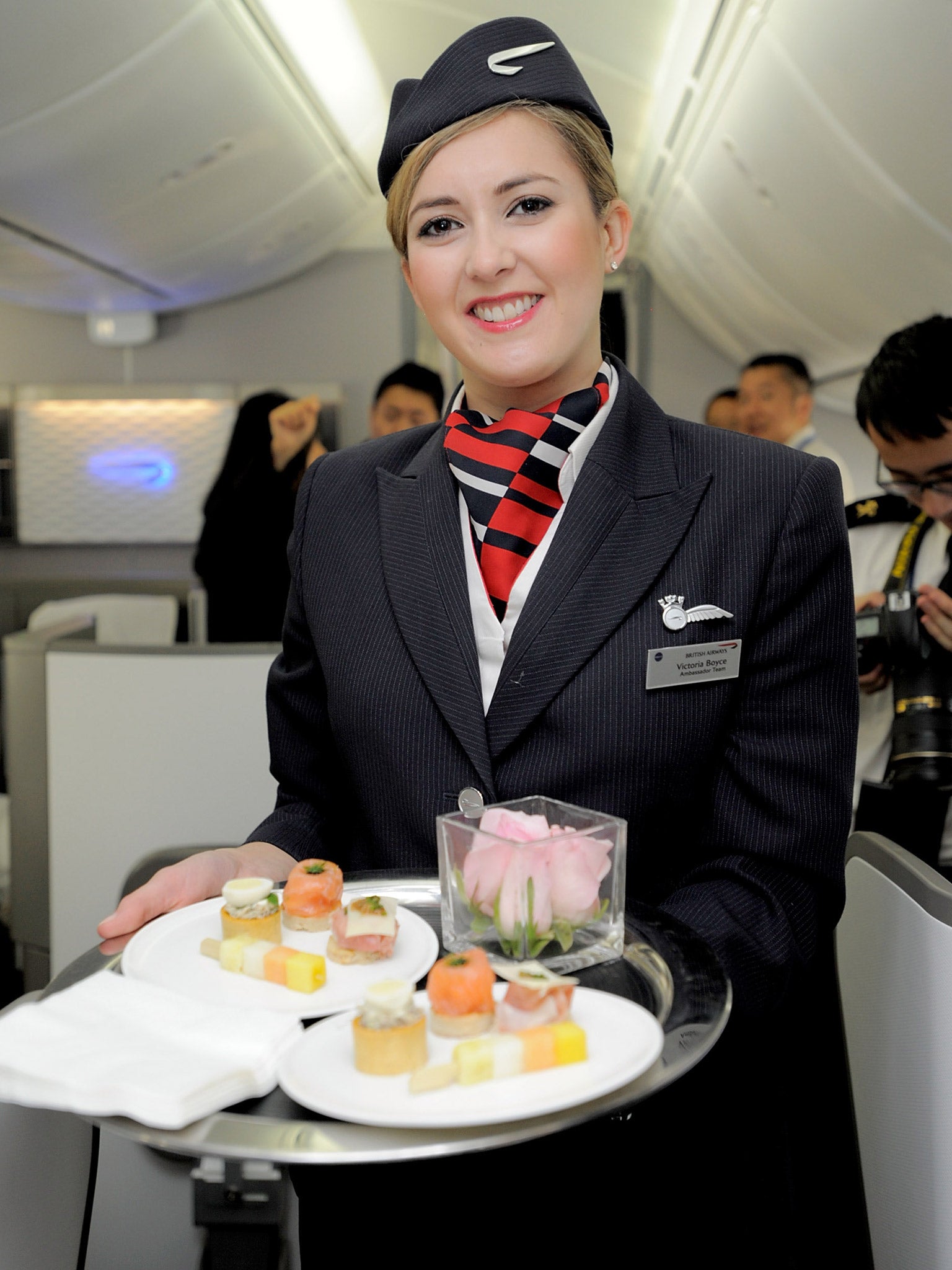 A British Airways attendant welcomes a passenger (Getty)