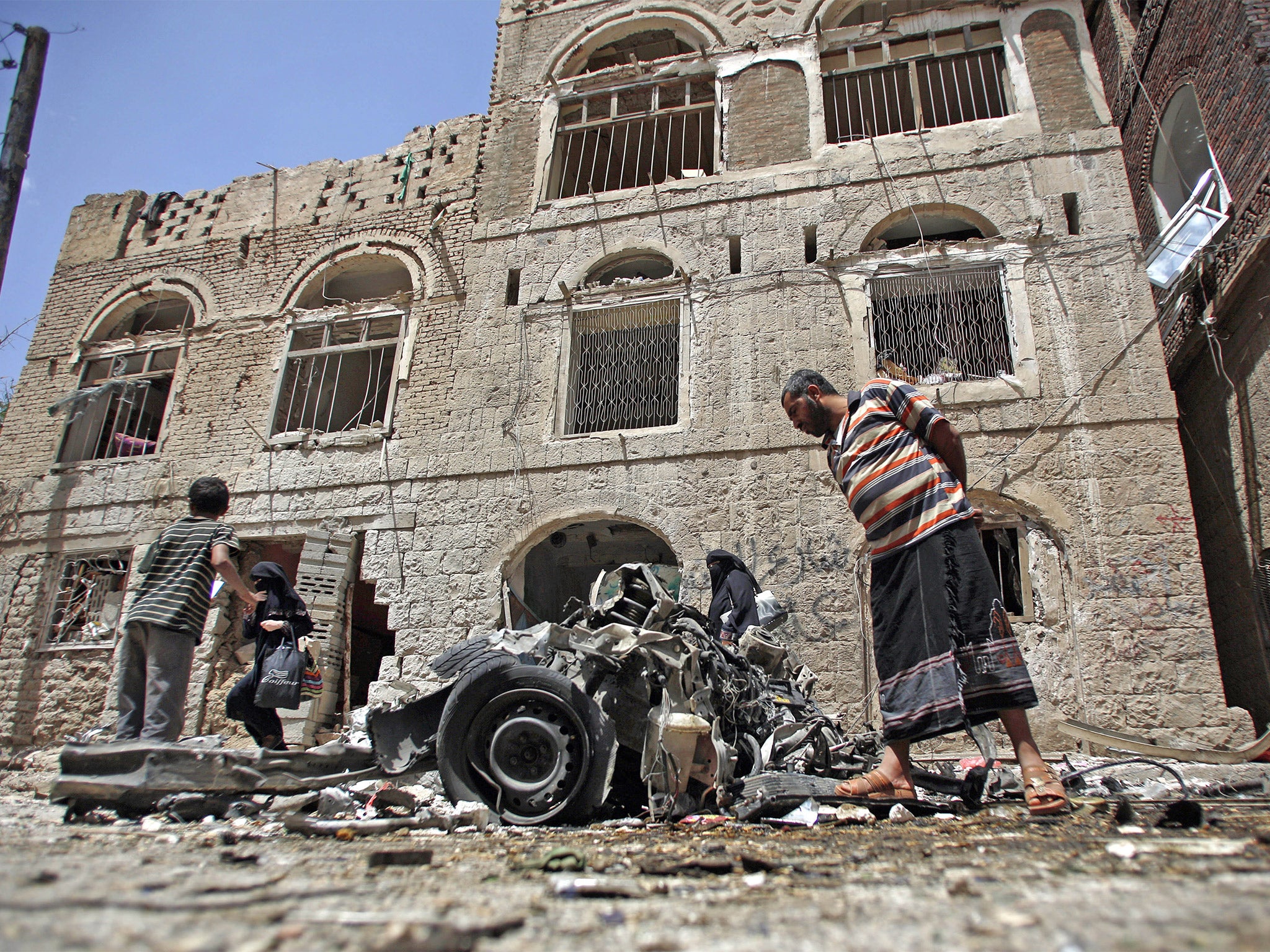 Yemeni civilians examine the wreck of a car-bomb in Sanaa earlier this week