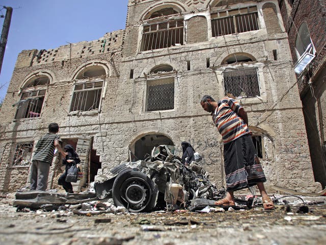 Yemeni civilians examine the wreck of a car-bomb in Sanaa earlier this week 