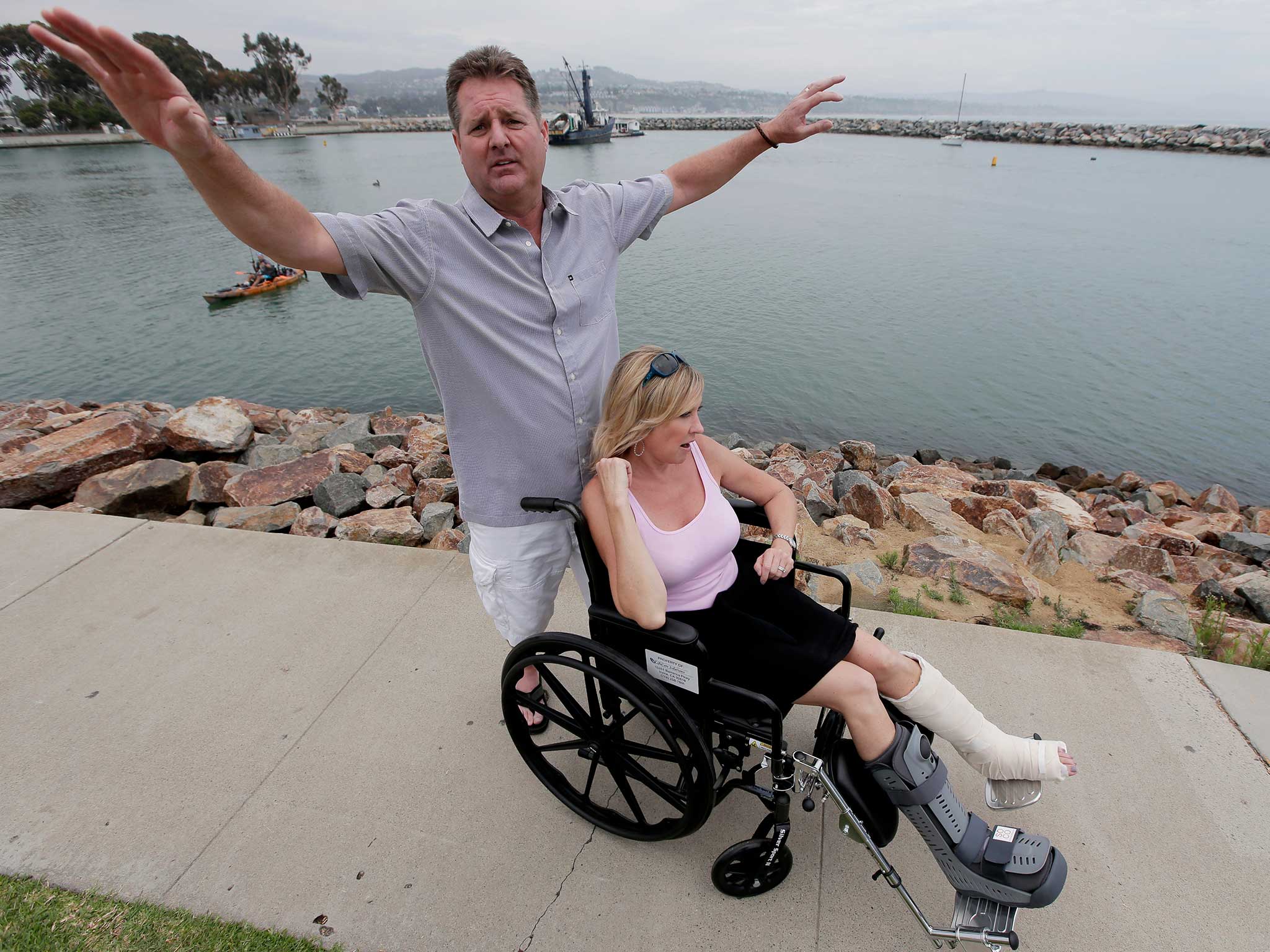 Mr Frickman gestures the size of the animal which landed on his wife, pictured in wheelchair