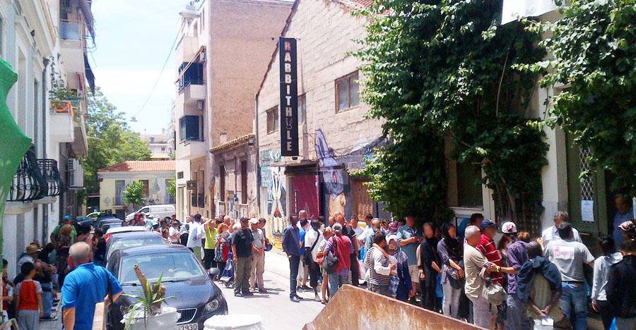 People line up in Athens for lunch from Food From the Heart Foundation