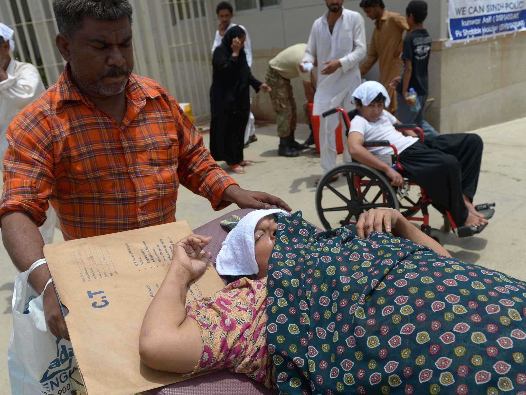 Pakistani relatives care for a heatstroke victim at a hospital in Karachi on June 30, 2015