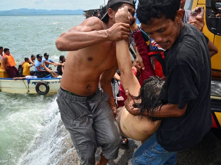 Men carry the dead body of passenger during the search and rescue operation