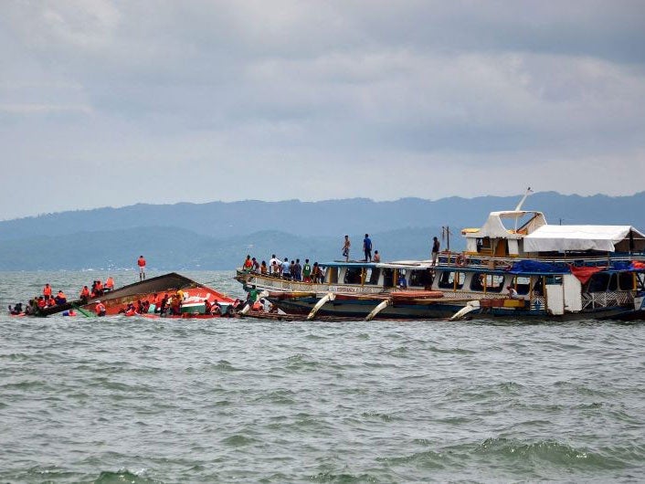 Fishing boats joined the rescue effort but had difficulty getting to trapped passengers in the overturned boat (left)