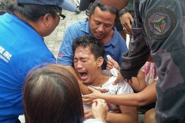 A survivor of a passenger ferry that capsized in rough waters cries after arriving at the pier in Ormoc City