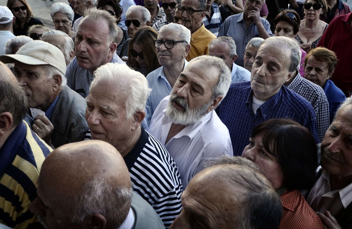 Pensioner wait to get their pensions outside a National Bank of Greece branch in central Athens