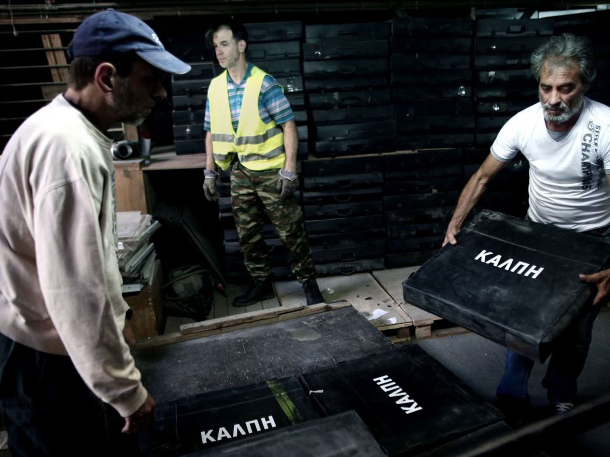 Municipal workers carry ballot boxes into a warehouse in Athens on July 2, 2015, in preparation for the upcoming referendum on austerity