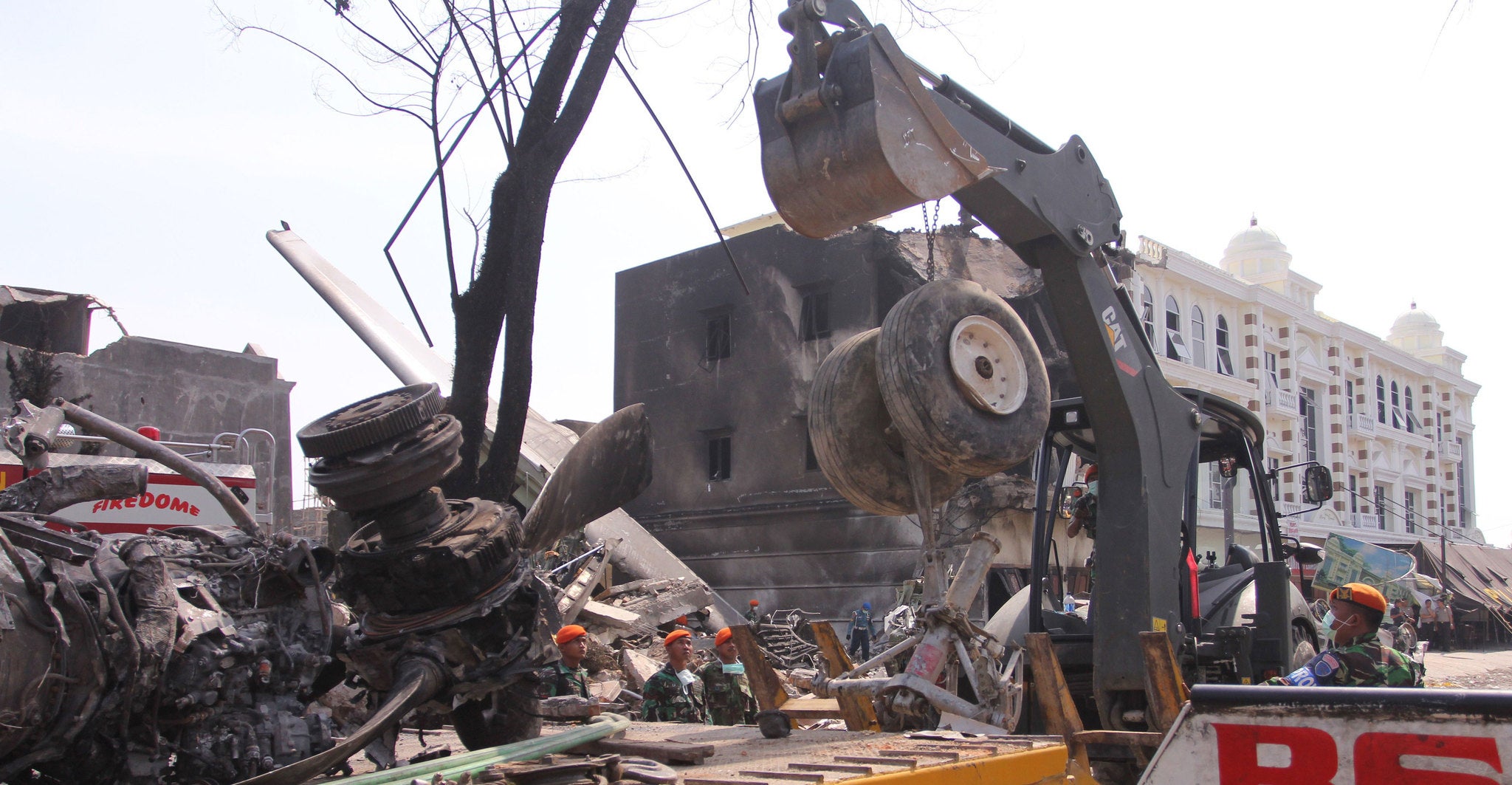 Recovered plane parts are placed on a truck as rescuers recovered bodies from the crash site of an Indonesian Air Force C-130 Hercules aircraft