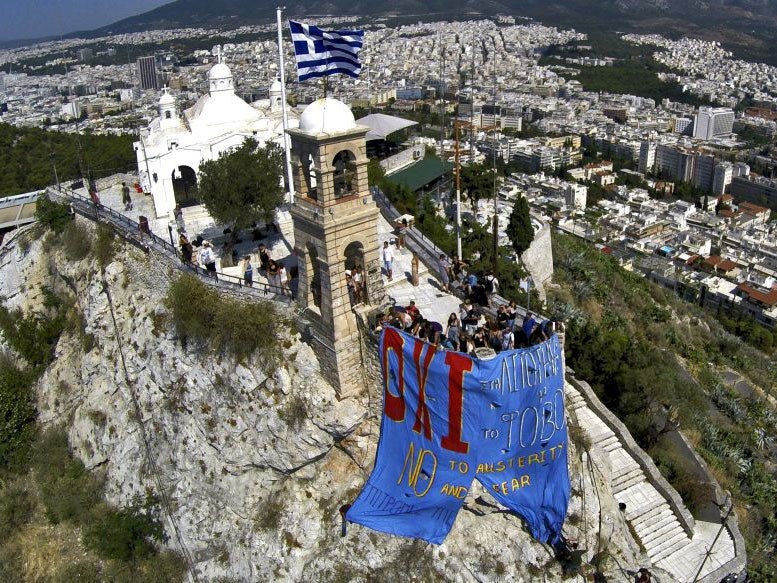 Anti-EU protesters hang a banner from Lycabettus hill in Athens