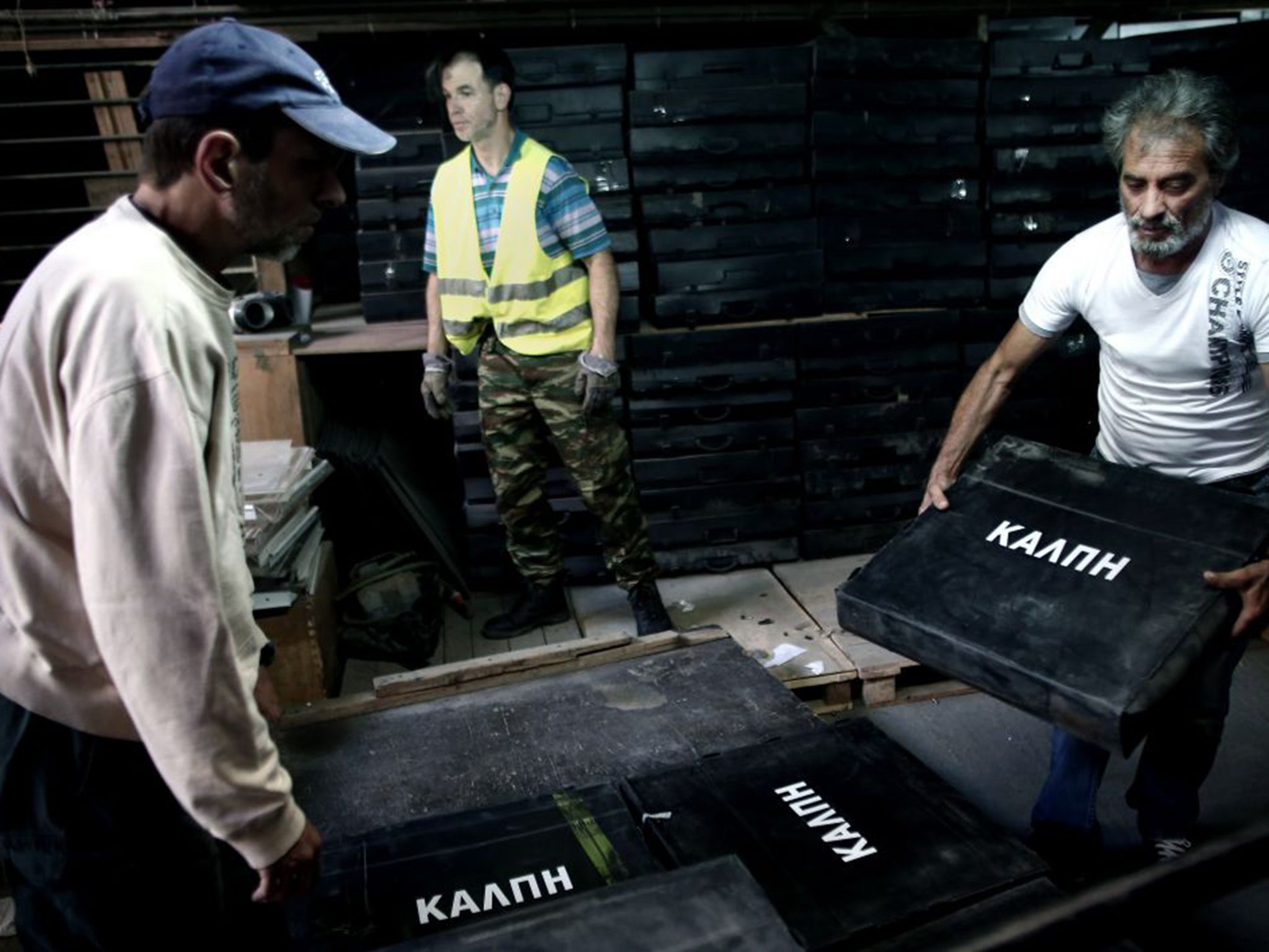 Municipal workers carry ballot boxes into a warehouse in Athens in preparation for the coming referendum