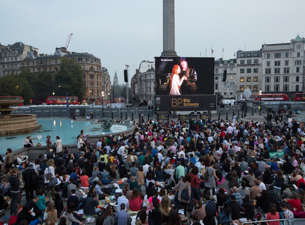 Members of the public prepare to watch a performance of Verdi's opera 'Rigoletto' on a big screen in Trafalgar Square displaying a live relay from The Royal Opera House on September 17, 2014 